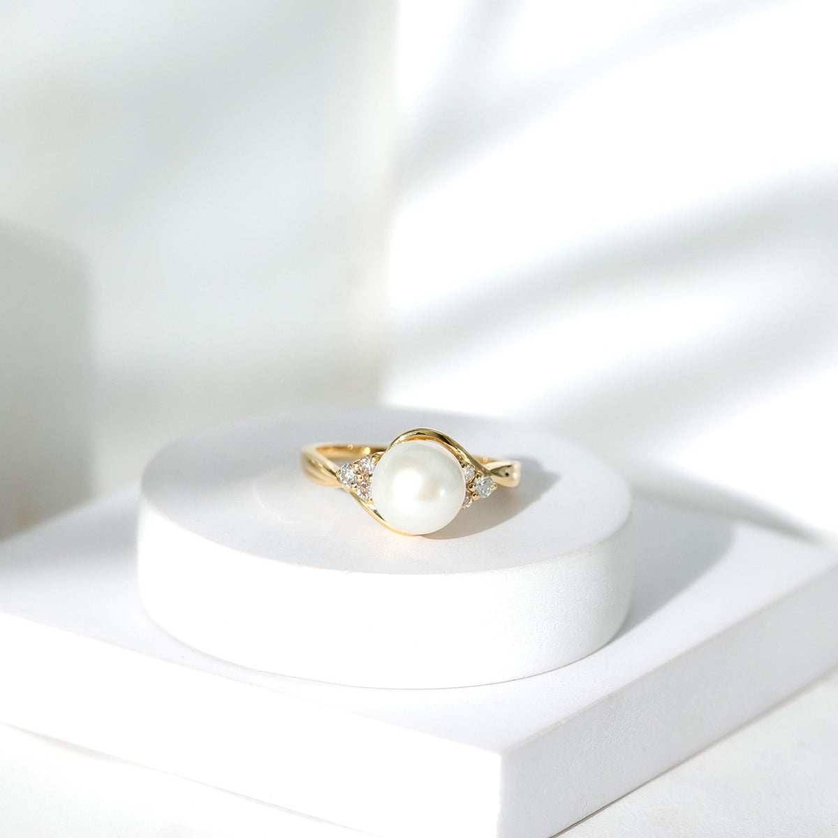 Natural 7.4-carat freshwater pearl engagement ring with diamond trio, set in a rose gold band by Rosec Jewels.