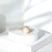 Natural 7.4-carat freshwater pearl engagement ring with diamond trio, set in a rose gold band by Rosec Jewels.
