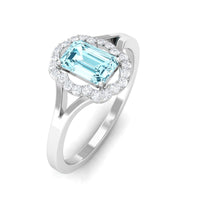 Rosec Jewels emerald cut aquamarine engagement ring with diamond floral halo, showcasing intricate design and sparkling gemstones.
