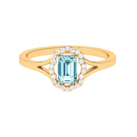 Emerald cut aquamarine engagement ring with diamond floral halo setting, showcasing intricate design and sparkling gemstones.