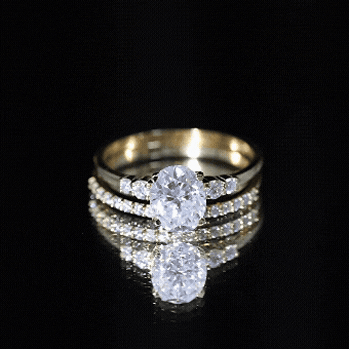 Yellow gold oval cut moissanite engagement ring with matching wedding band set by Rosec Jewels, showcasing sparkling gemstone details.