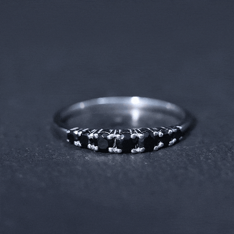 Round cut graduated black onyx half eternity ring by Rosec Jewels, featuring alternating black onyx stones set in a sleek band.