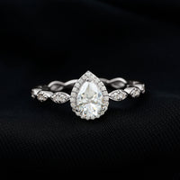 Moissanite teardrop engagement ring with scalloped shank from Rosec Jewels, featuring a sparkling central stone and intricate band detail.
