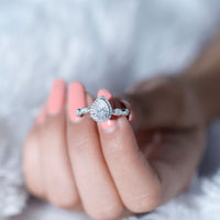 Moissanite teardrop engagement ring with scalloped shank from Rosec Jewels, featuring a sparkling gemstone and intricate band design.