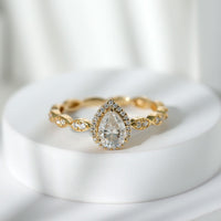 Moissanite teardrop engagement ring with scalloped shank from Rosec Jewels, showcasing sparkling gemstone and intricate band detail.
