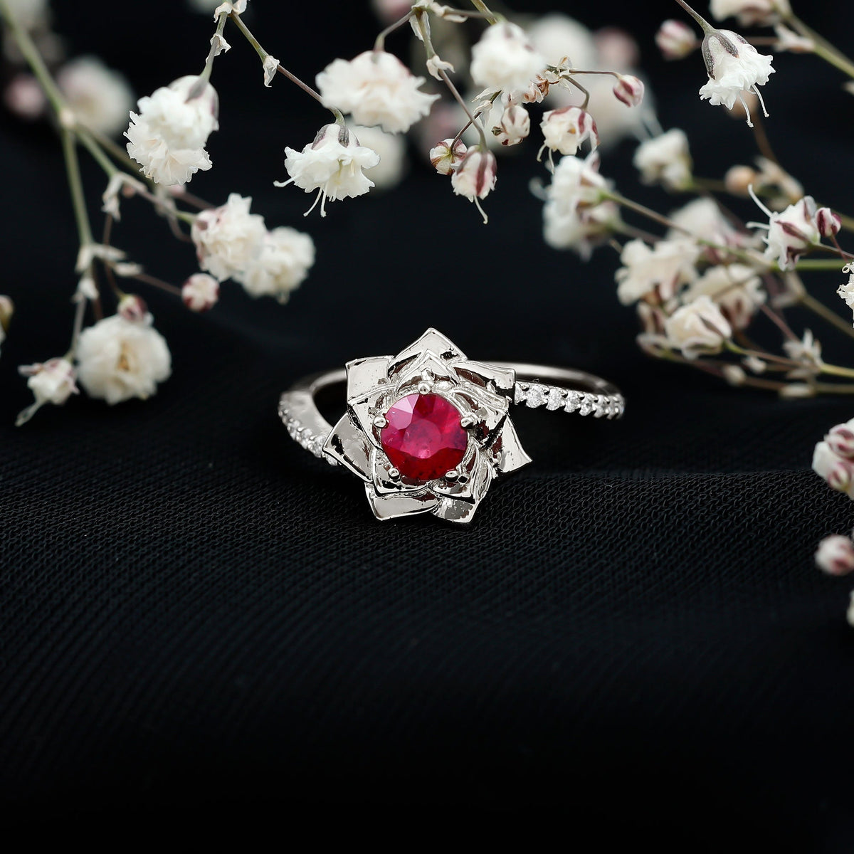 Natural 0.6 carat ruby flower engagement ring with diamond bypass shank by Rosec Jewels, showcasing a floral ruby centerpiece and elegant band.