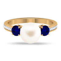 White pearl and sapphire 3-stone engagement ring with diamonds by Rosec Jewels, featuring elegant gemstone accents and intricate band design.