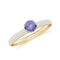 Natural Tanzanite engagement ring by Rosec Jewels with pave diamond side stones and intricate metal band design.