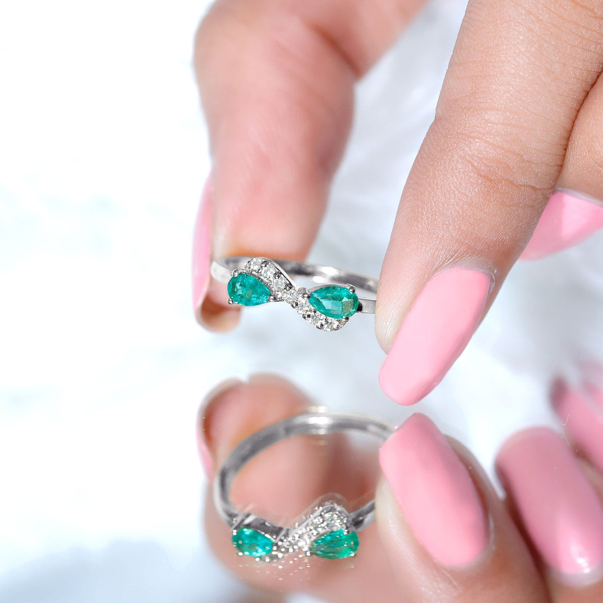 Natural pear-shaped emerald and diamond infinity promise ring by Rosec Jewels, featuring elegant gemstone and intricate band design.