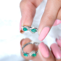 Natural pear-shaped emerald and diamond infinity promise ring by Rosec Jewels, featuring elegant gemstone and intricate band design.