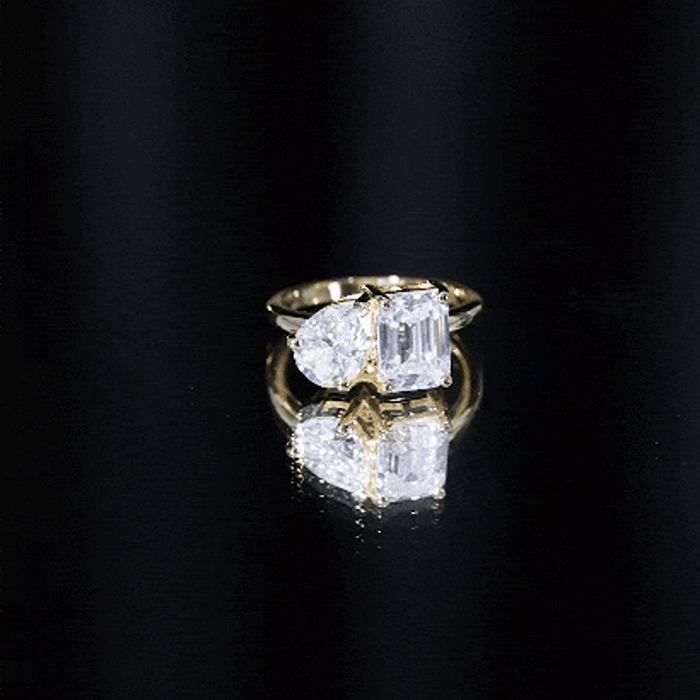 Yellow gold Pear and Emerald cut Moissanite Toi Et Moi engagement ring featuring two sparkling stones set in a romantic design.