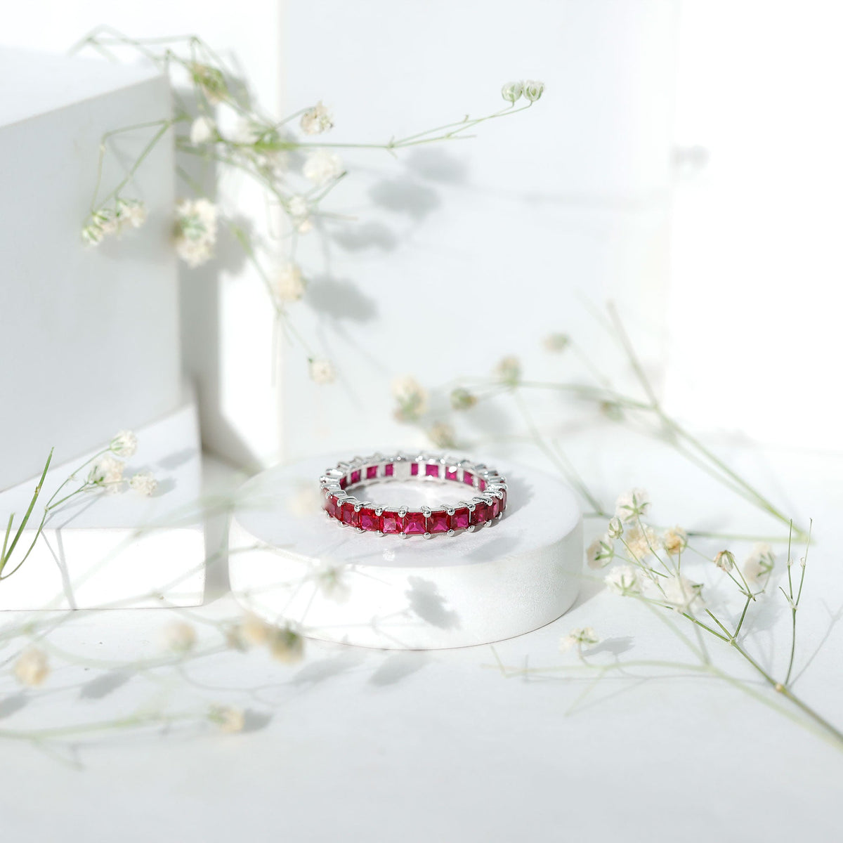 Rosec Jewels princess cut lab-grown ruby eternity wedding band for women, showcasing sparkling ruby stones in a continuous circle.