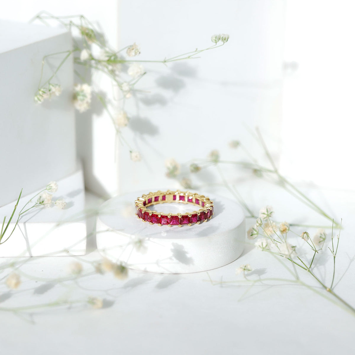 Princess cut lab-grown ruby eternity wedding band for women by Rosec Jewels, featuring a continuous row of sparkling ruby gemstones.