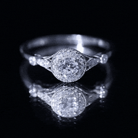 Round cut moissanite antique engagement ring with intricate band details, featuring a central sparkling stone set in a vintage-inspired design.