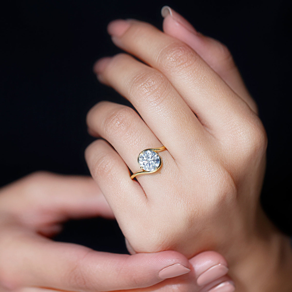 Round cut 2 carat moissanite solitaire engagement ring with bypass shank by Rosec Jewels, shown from a side angle.