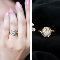 Rosec Jewels certified moissanite bezel set engagement ring with crossover shank, showcasing a sparkling central stone and elegant band.