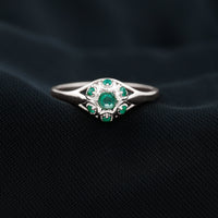 Vintage-inspired emerald flower engagement ring by Rosec Jewels featuring a central emerald gemstone and intricate floral design.