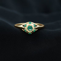 Vintage-inspired emerald flower engagement ring by Rosec Jewels featuring a central emerald gemstone with floral detailing.