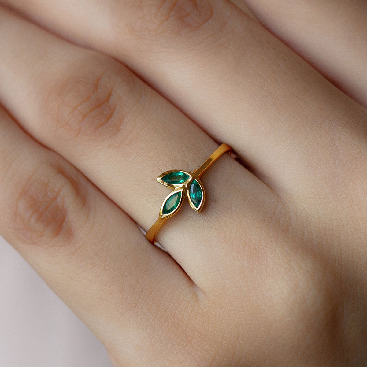 Marquise cut emerald leaf promise ring in bezel setting by Rosec Jewels, showcasing detailed leaf design and sparkling green gemstone.