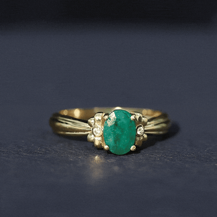 Oval cut emerald solitaire engagement ring with bow design by Rosec Jewels, showcasing the elegant green gemstone and intricate band details.