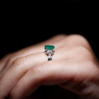 Oval cut emerald solitaire engagement ring with bow design by Rosec Jewels, showcasing the elegant ring with detailed craftsmanship.