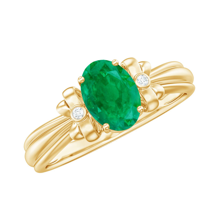 Oval cut emerald solitaire engagement ring with bow design, featuring a gold band and intricate detailing by Rosec Jewels.