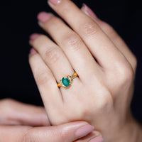 Oval cut emerald solitaire engagement ring with bow design by Rosec Jewels, showcasing a sparkling green gemstone and elegant craftsmanship.