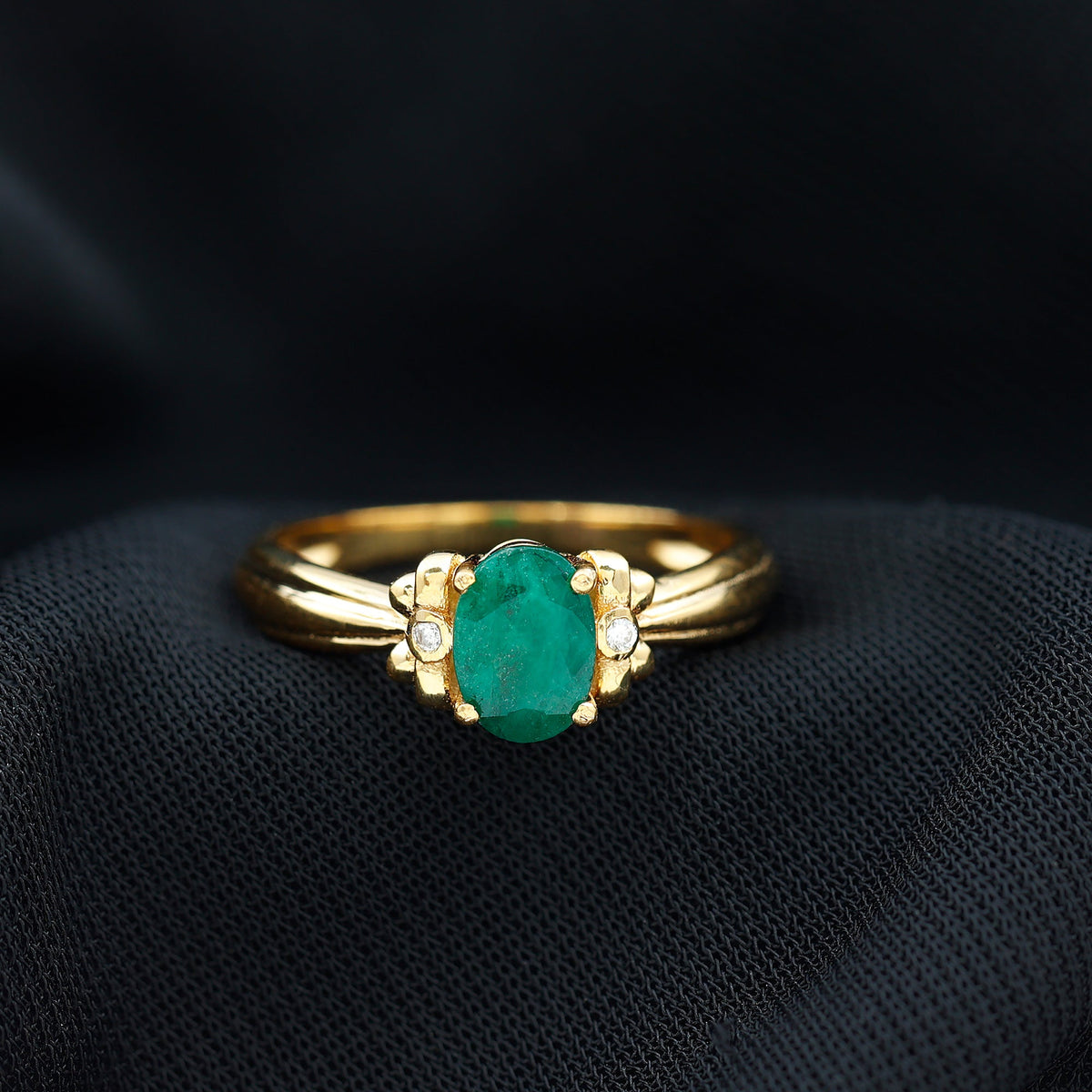 Oval cut emerald solitaire engagement ring with bow design by Rosec Jewels, showcasing a green emerald center stone and elegant craftsmanship.