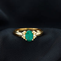 Oval cut emerald solitaire engagement ring with bow design by Rosec Jewels, showcasing a green emerald center stone and elegant craftsmanship.