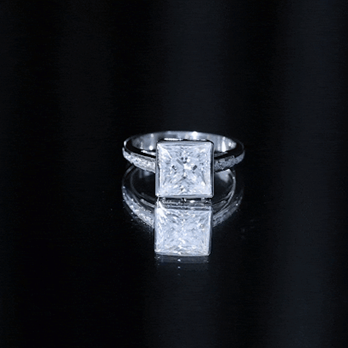 Yellow gold moissanite engagement ring by Rosec Jewels featuring a bezel and channel set design, showcasing sparkling stones.