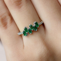 Baguette cut emerald promise ring with diamond side stones from Rosec Jewels, showcasing the elegant ring design and sparkling gemstones.