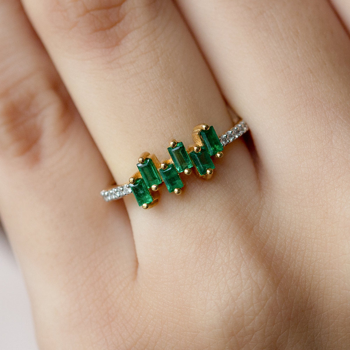 Rosec Jewels emerald promise ring with baguette cut emerald center and diamond side stones, elegant and sparkling jewelry piece.