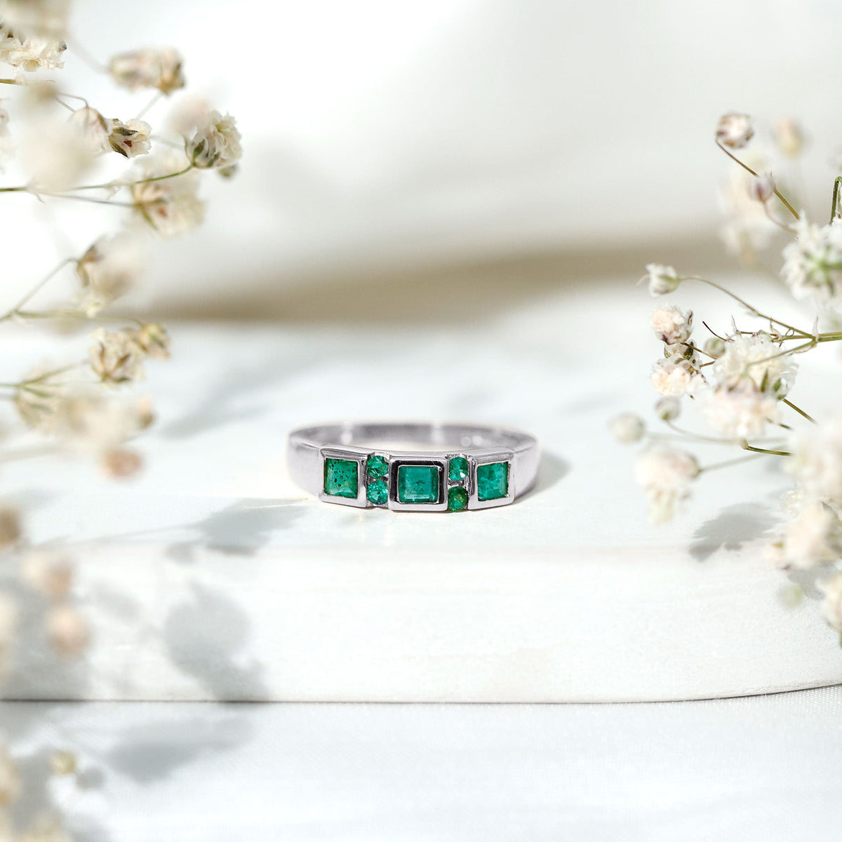 Natural emerald princess cut band ring by Rosec Jewels featuring a sparkling green emerald gemstone and a sleek gold band.