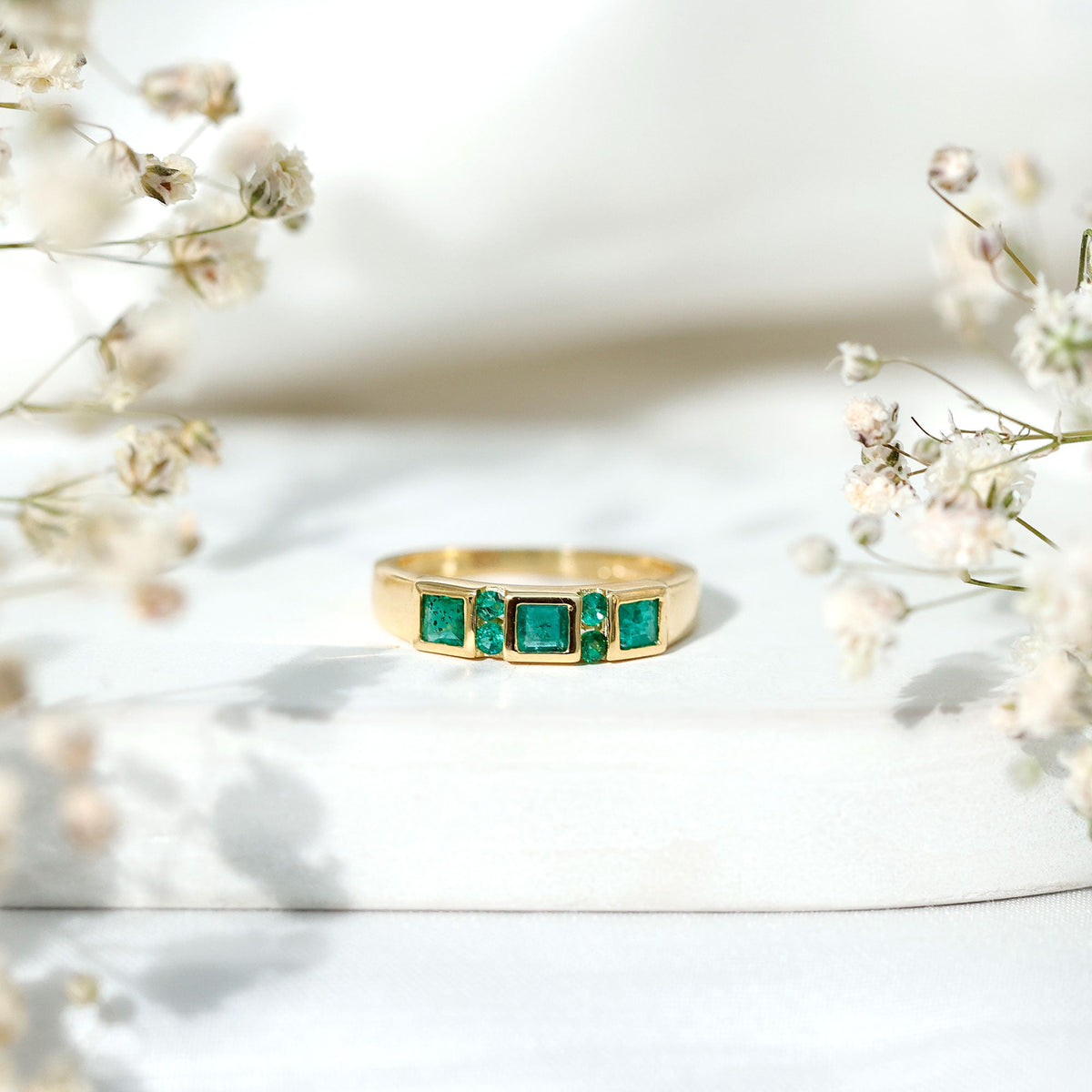Natural emerald princess cut band ring by Rosec Jewels featuring a sparkling green emerald set in a sleek gold band.