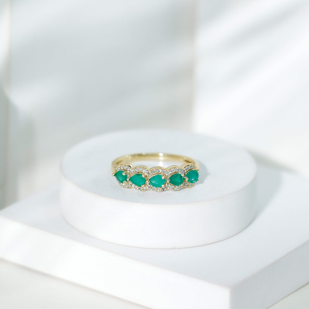Pear-shaped emerald anniversary wedding ring with diamond accents, crafted by Rosec Jewels, featuring a detailed gold band.