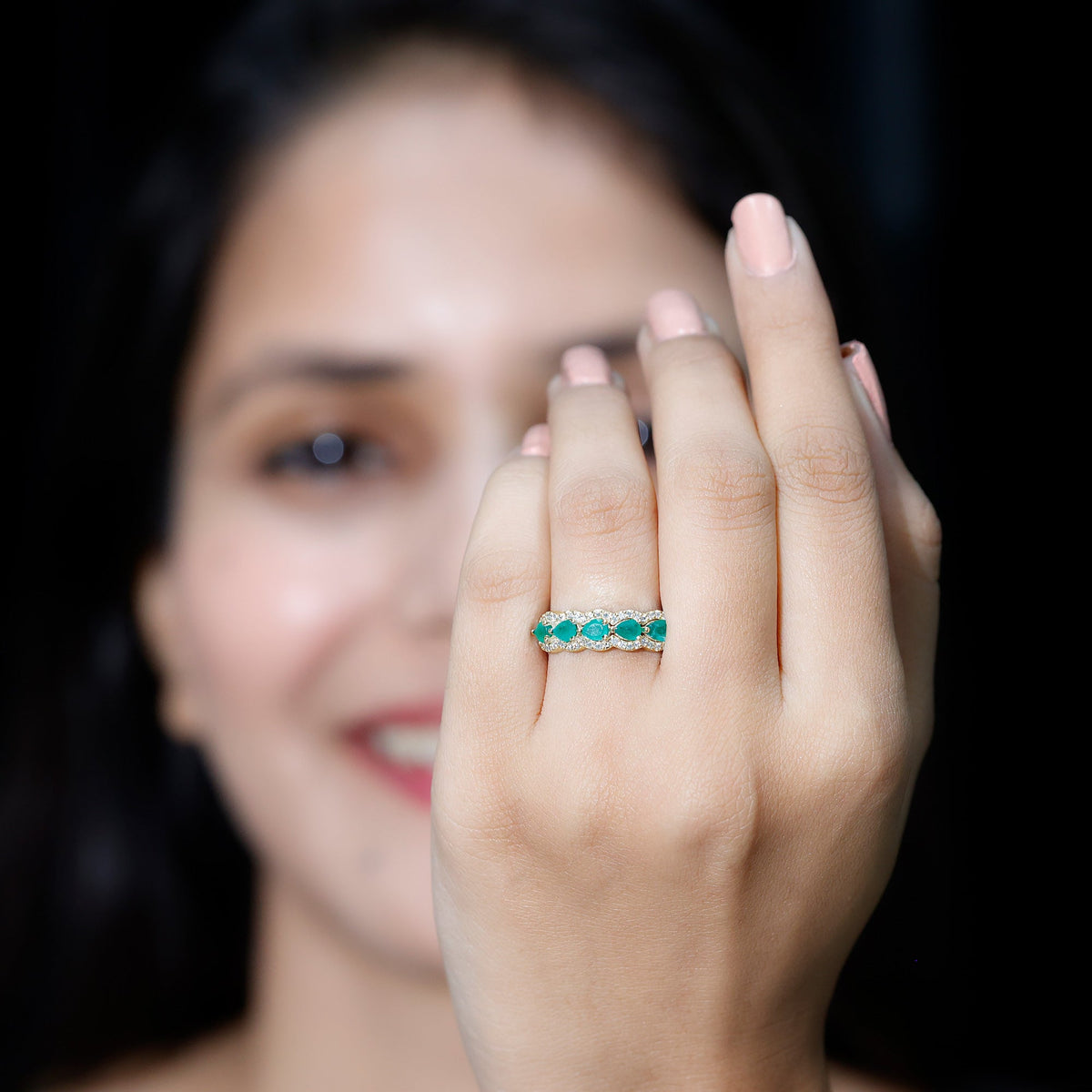 Pear-shaped emerald anniversary wedding ring with diamond accents by Rosec Jewels, showcasing a detailed gold band and sparkling gemstones.