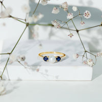 Natural freshwater pearl, blue sapphire, and diamond 3-stone engagement ring by Rosec Jewels featuring elegant design and fine craftsmanship.