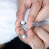 Cultured freshwater pearl engagement ring with blue sapphire accents, crafted by Rosec Jewels, showcasing elegant design.
