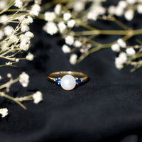 Cultured freshwater pearl and blue sapphire engagement ring from Rosec Jewels, showcasing elegant design and sparkling gemstones.