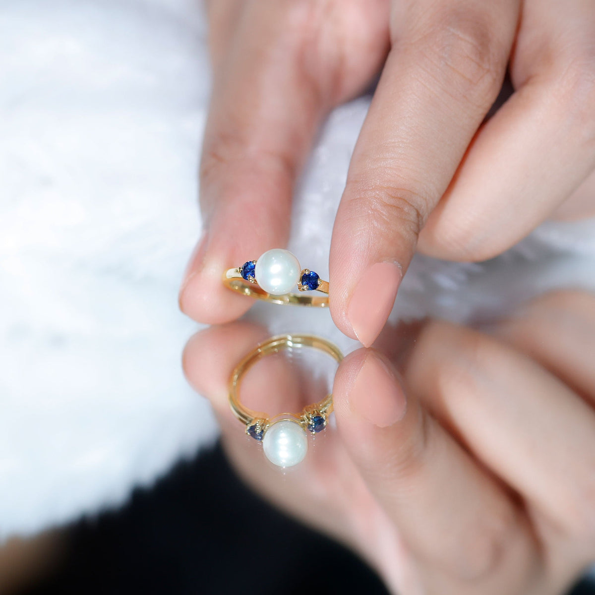 Cultured freshwater pearl engagement ring with blue sapphire accent, featuring a delicate band and elegant design by Rosec Jewels.