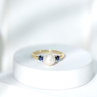 Cultured freshwater pearl engagement ring with blue sapphire accent, elegant rose gold band by Rosec Jewels.