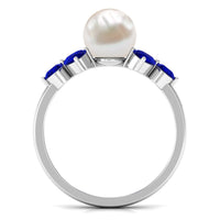 Natural 7.4 carat freshwater pearl engagement ring with blue sapphire trio from Rosec Jewels, featuring a delicate silver band.