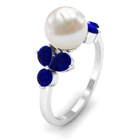 Natural 7.4 carat freshwater pearl engagement ring with blue sapphire trio by Rosec Jewels, featuring a delicate ring setting.