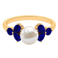 Natural 7.4 carat freshwater pearl engagement ring with blue sapphire trio, featuring elegant silver band by Rosec Jewels.