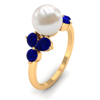 Natural 7.4 carat freshwater pearl engagement ring with blue sapphire trio, featuring a delicate rose gold band.