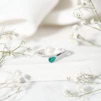 Cultured freshwater pearl and emerald toi et moi promise ring by Rosec Jewels, featuring a pearl and emerald set on a silver band.