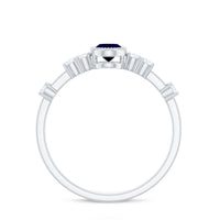 Vintage blue sapphire oval engagement ring with diamond accents, showcasing a rose gold band and intricate detailing.