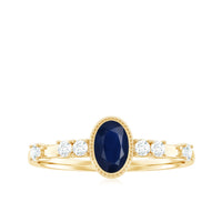 Vintage blue sapphire oval engagement ring with diamond accents from Rosec Jewels, showcasing intricate design and sparkling gemstones.
