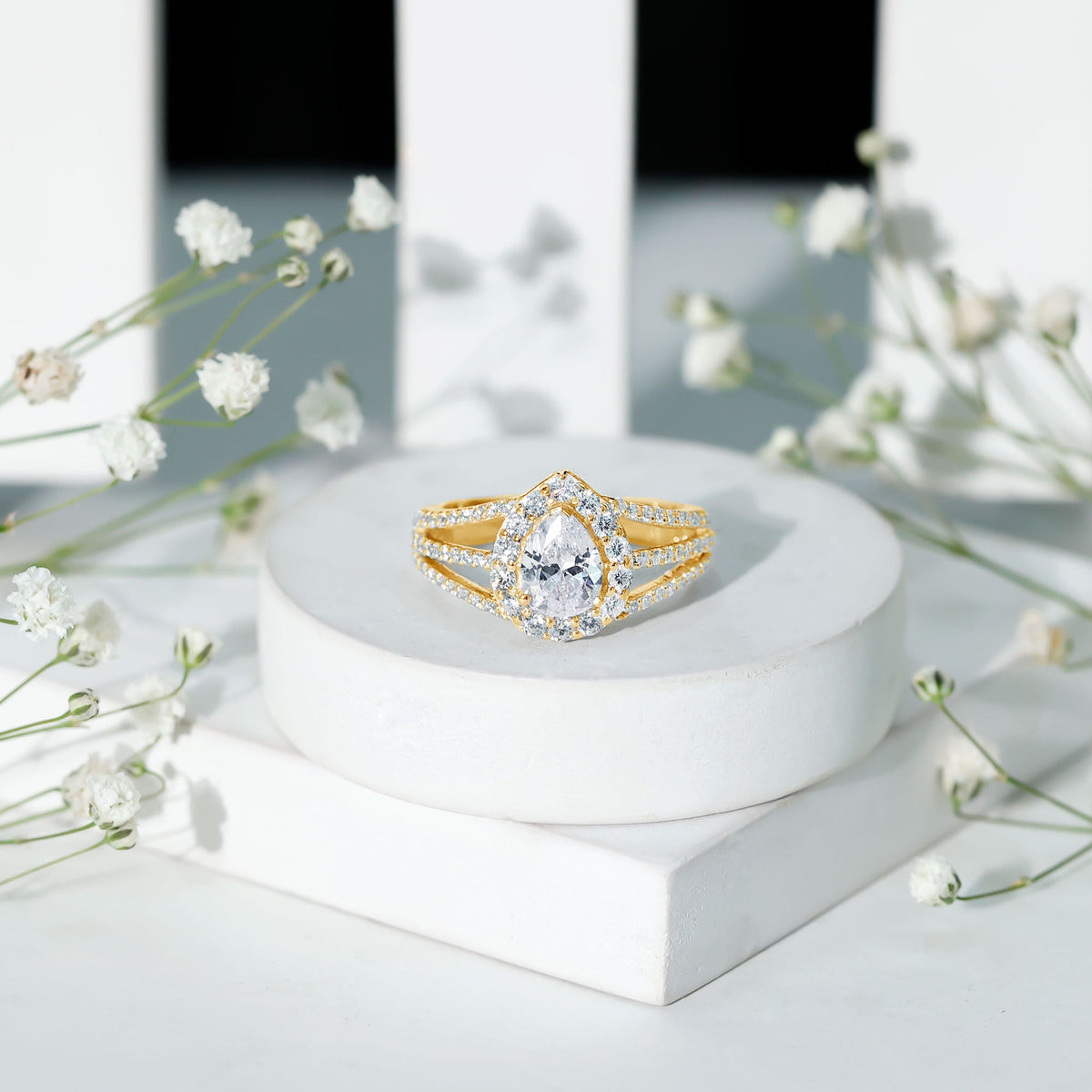 Pear-shaped cubic zirconia engagement ring with split shank design by Rosec Jewels, featuring sparkling stone settings.
