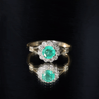 Emerald and diamond halo engagement ring by Rosec Jewels featuring a nature-inspired design with intricate detailing.